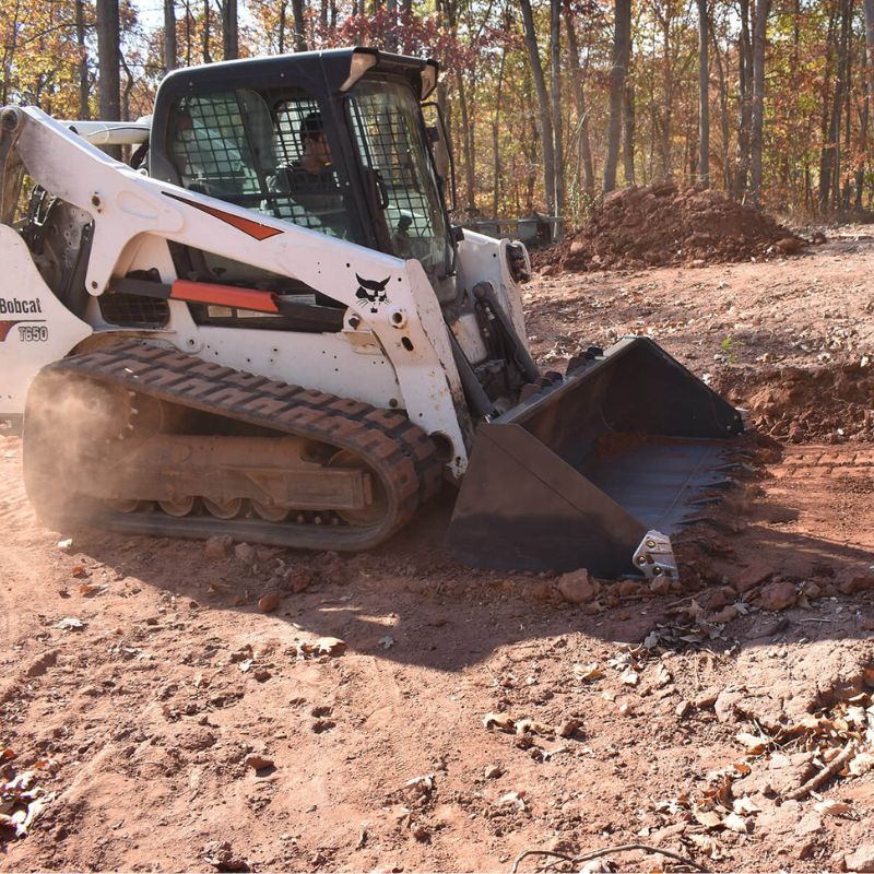 Bobcat T650 using a Roadrunner severe-duty bucket to move dirt on a jobsite