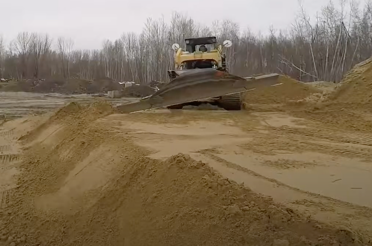skid steer with the grading blade attachment in action from skeer system