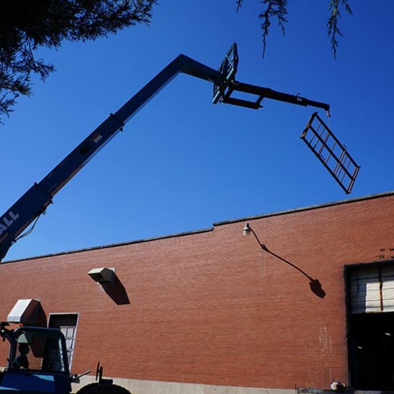 Blue Diamond Industrial Jib Boom lifting metal from onto a roof with a tele handler