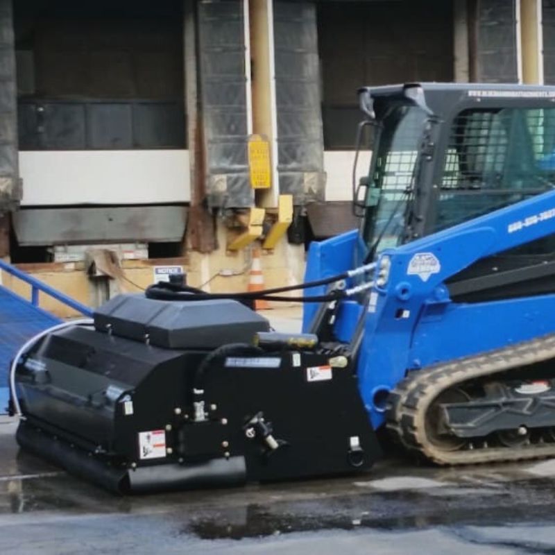 Skid Steer with Blue Diamond Pickup Broom Attachment.
