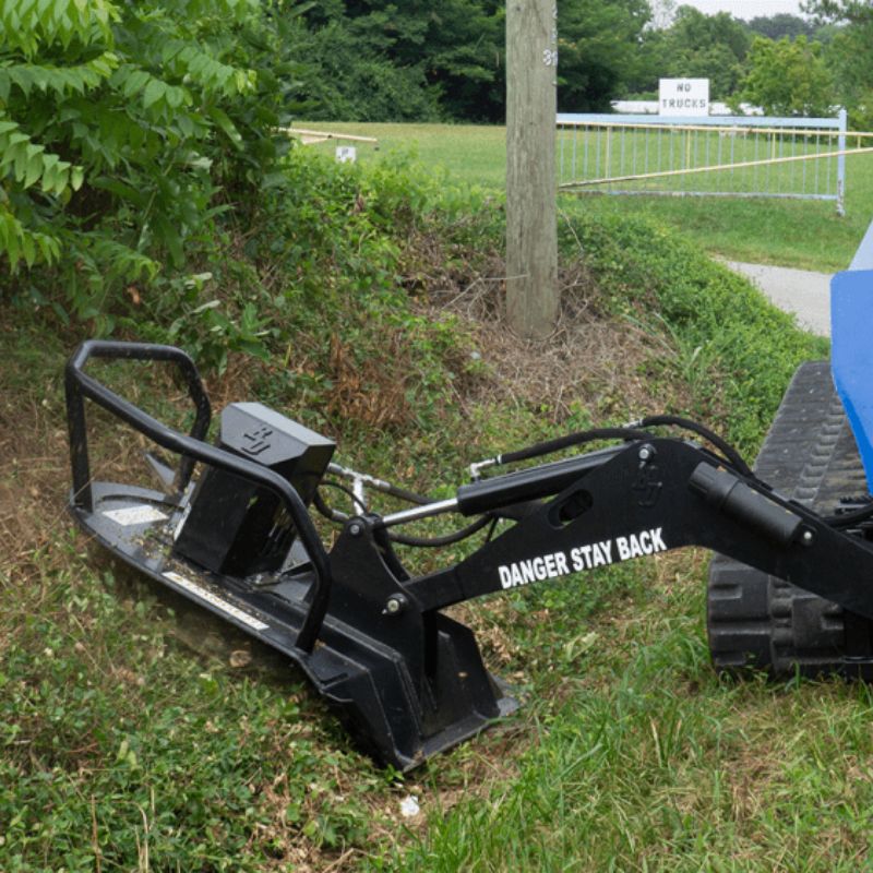 skid steer in action with the blue diamond swing arm brush cutter