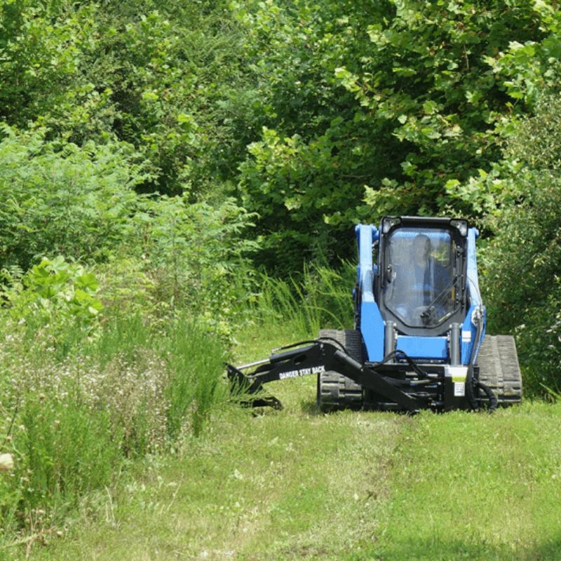 skid steer swing arm brush cutter attachment in the field