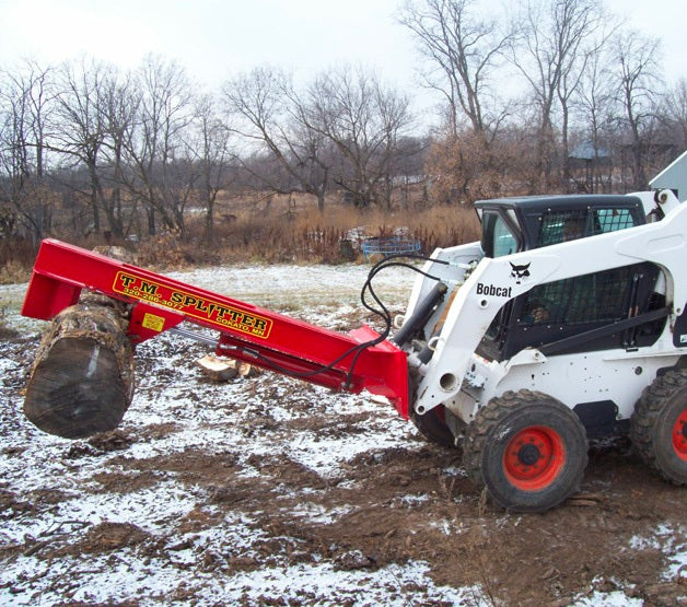 Bobcat skid steer with TM Manufacturing Skid splitter attachment lifting a large log