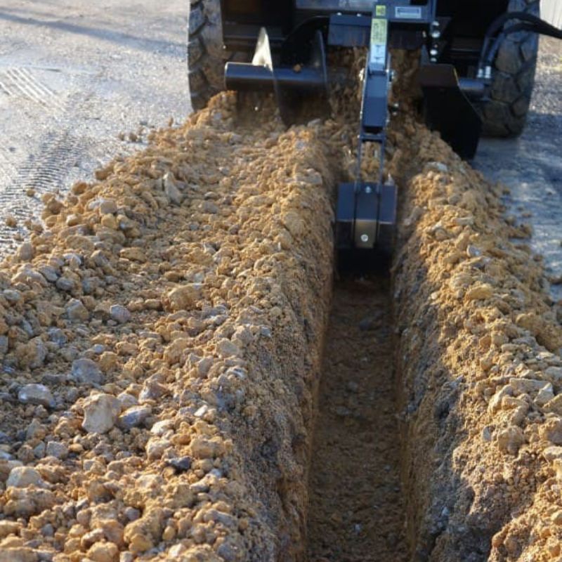 blue diamond trencher getting used by a skid steer