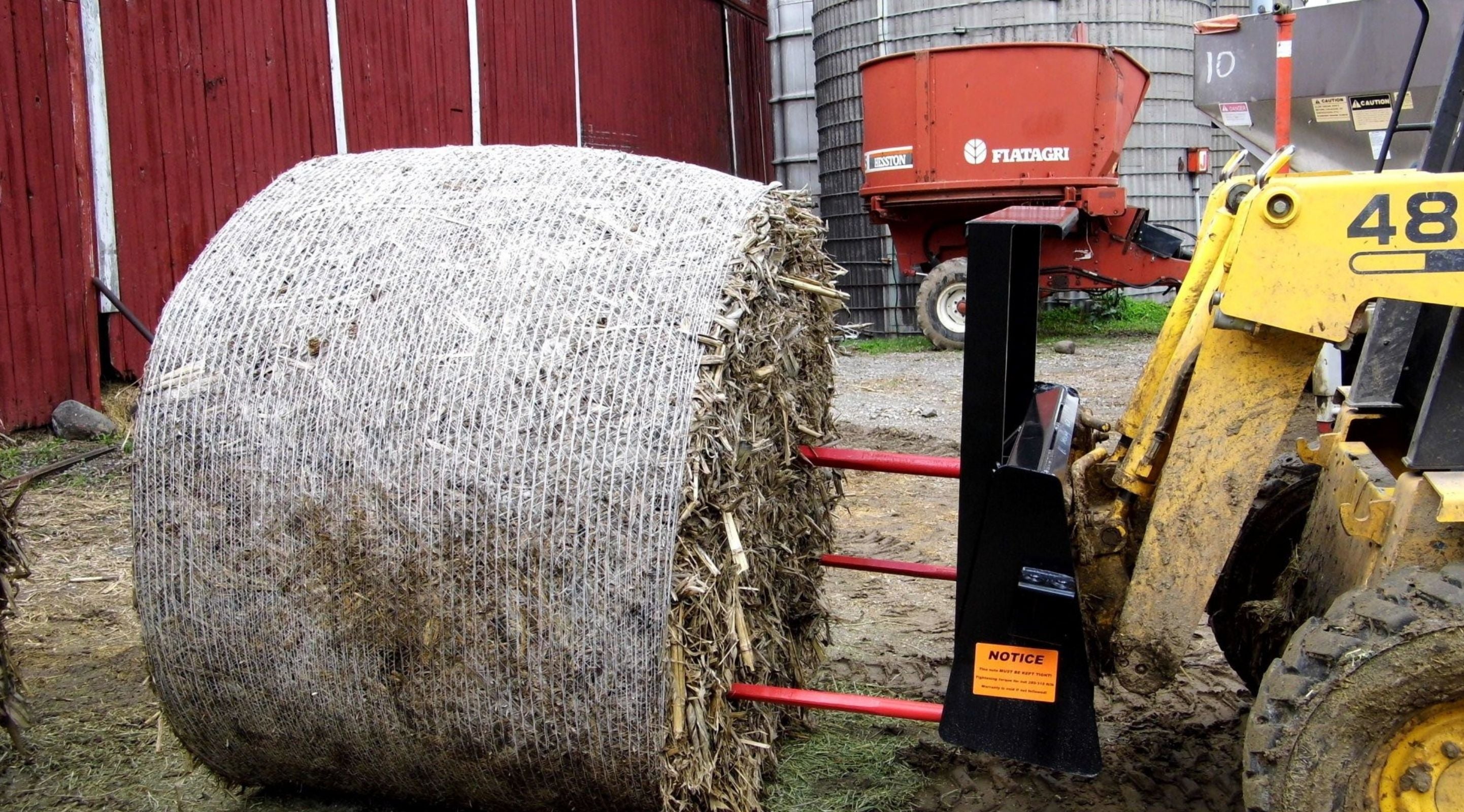 Skid steer moving bales with the bale spear attachment by Berlon 