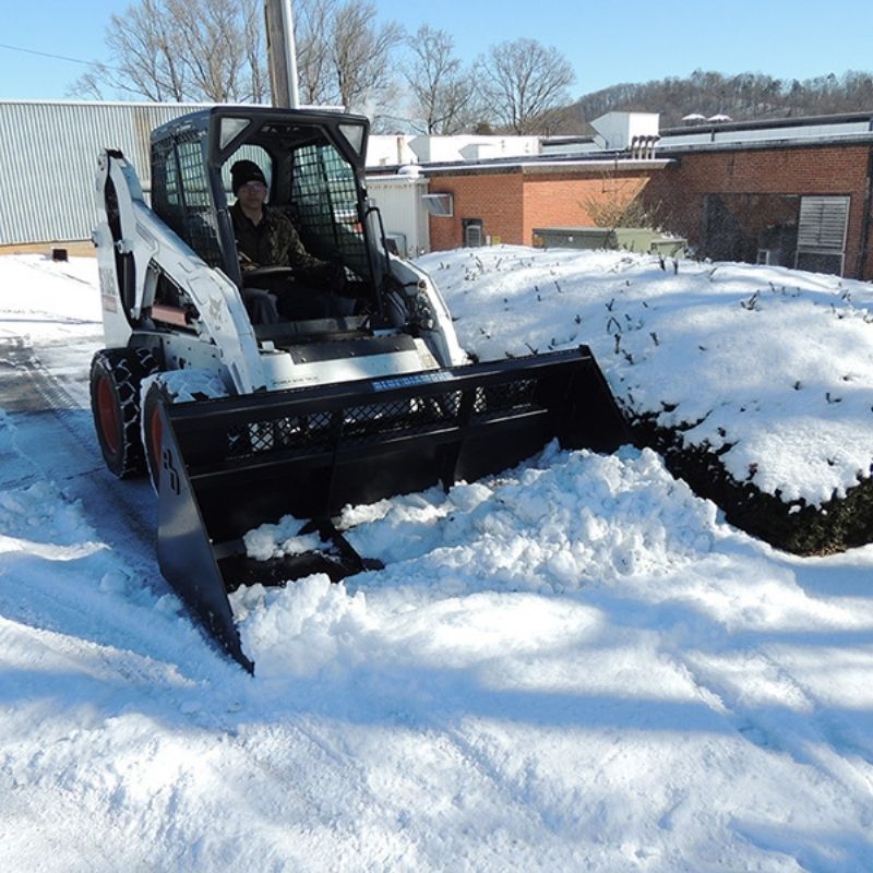 Bobcat skid steer clearing the snow with the snow bucket attachment from Blue Diamond