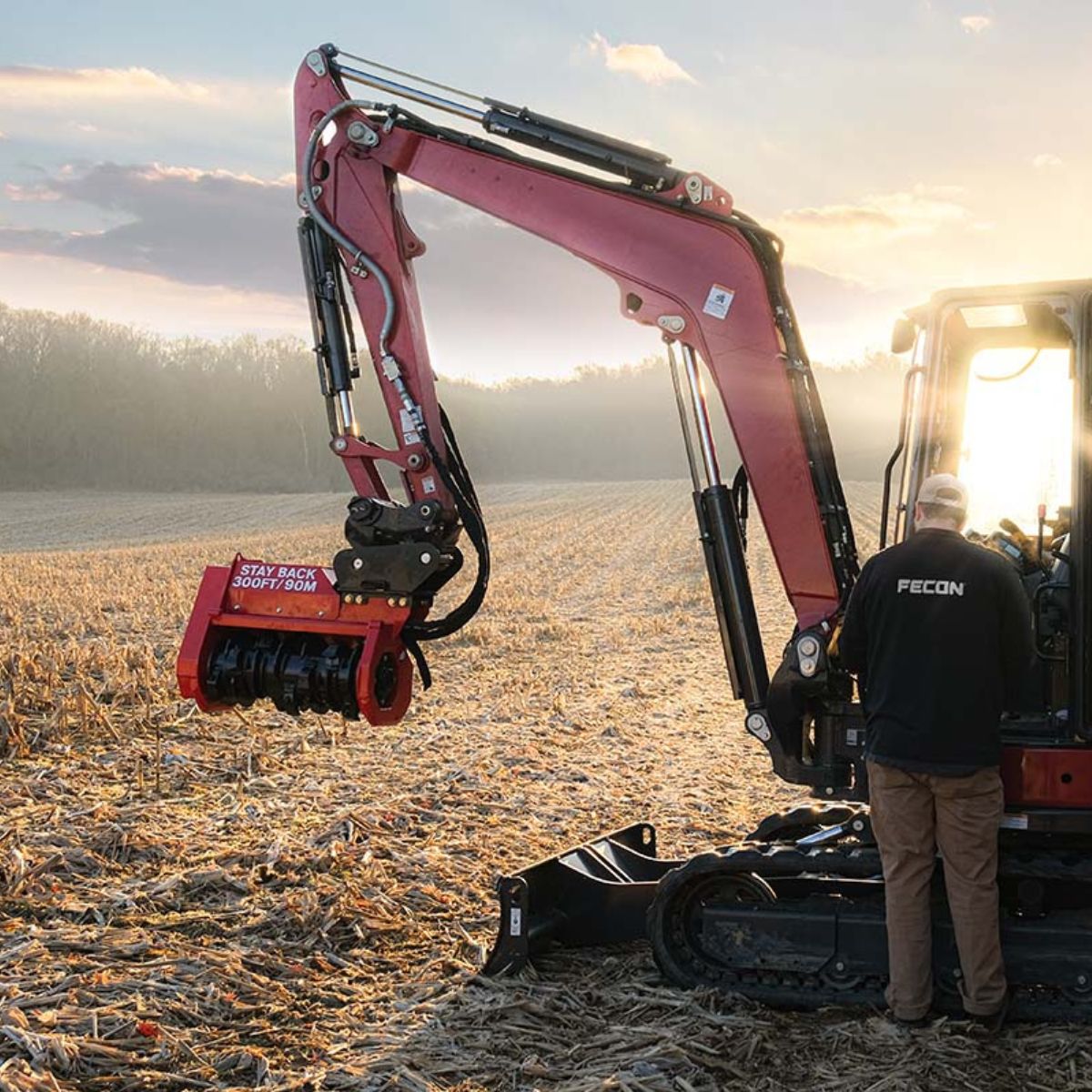 Fecon mini excavator mulching head attached to a Kubota excavator in a field at sunrise