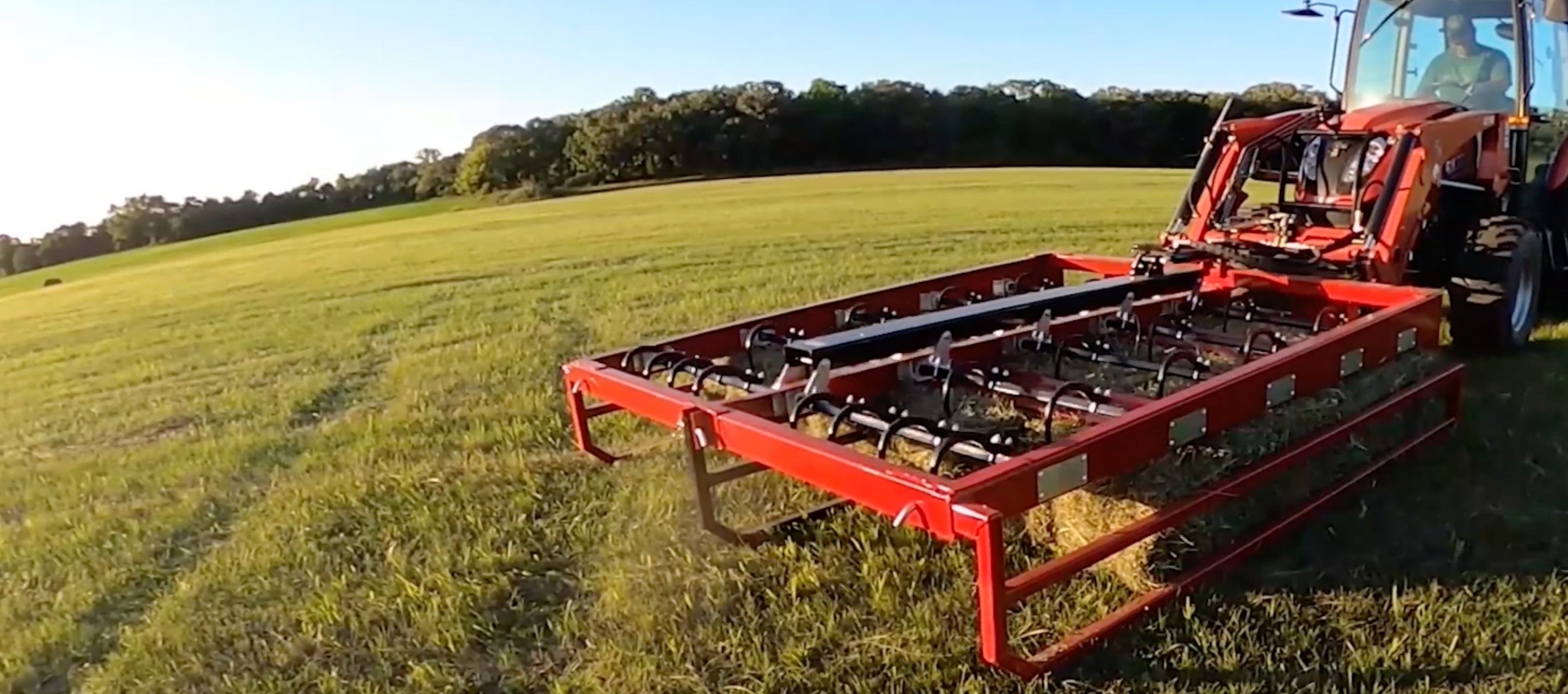 Tractor with the bale accumulator grapple attachment ready to collect bales to stack 