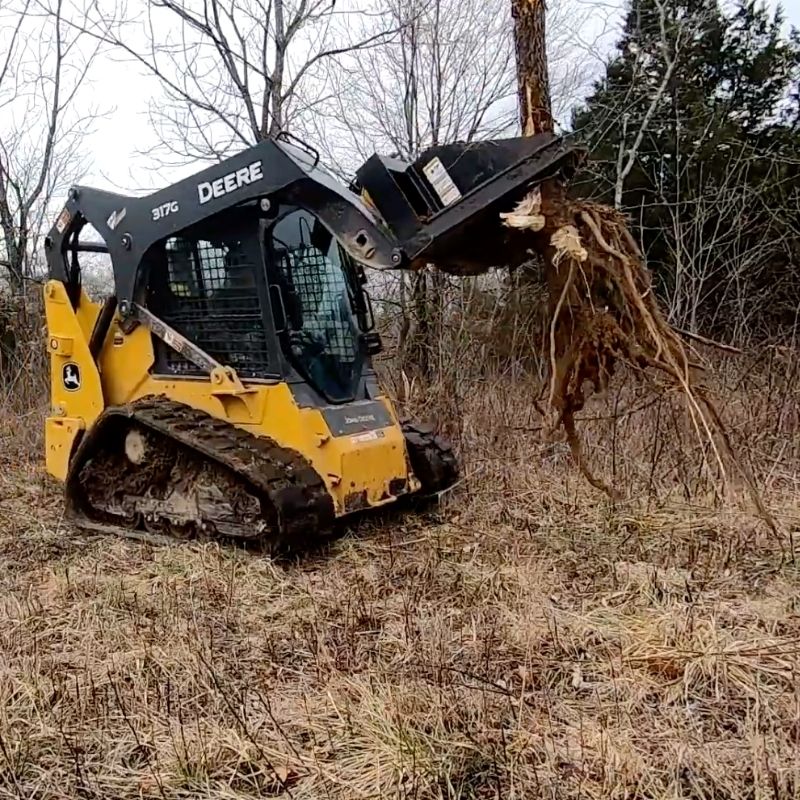 John Deere skid steer pulling trees using the Tree Puller attachment from Berlon