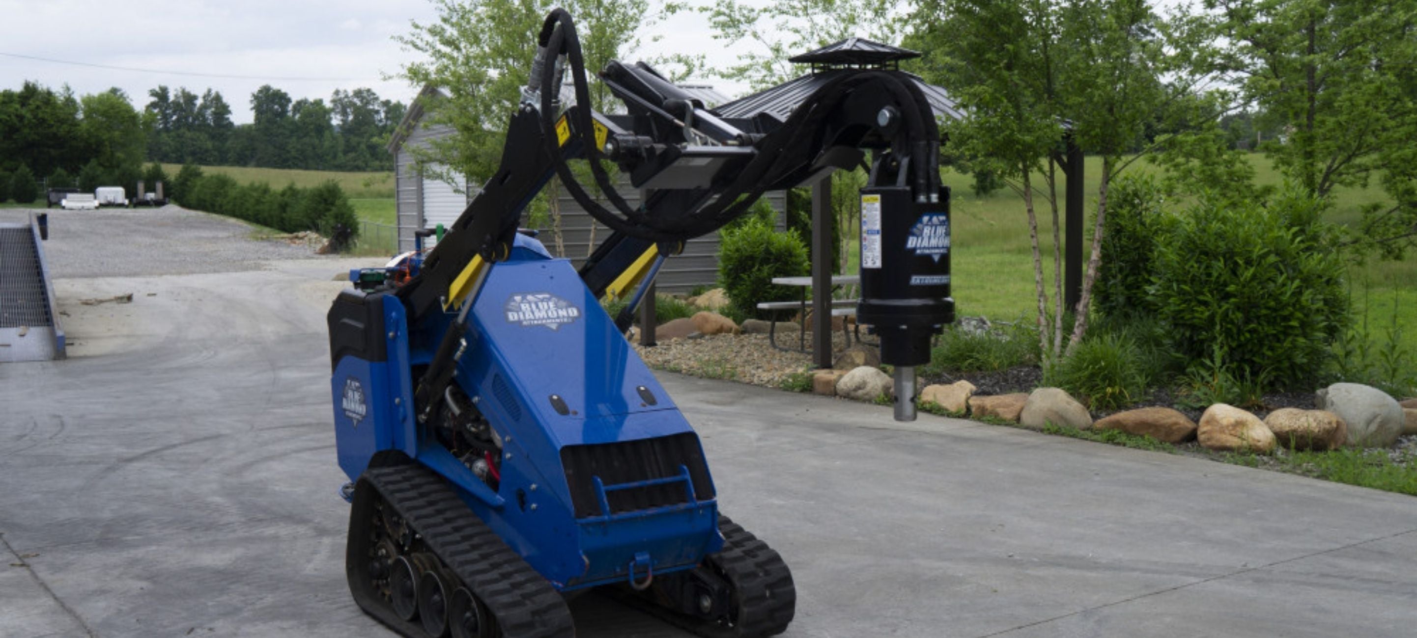 Blue diamond auger attachment on a mini skid steer ready to action