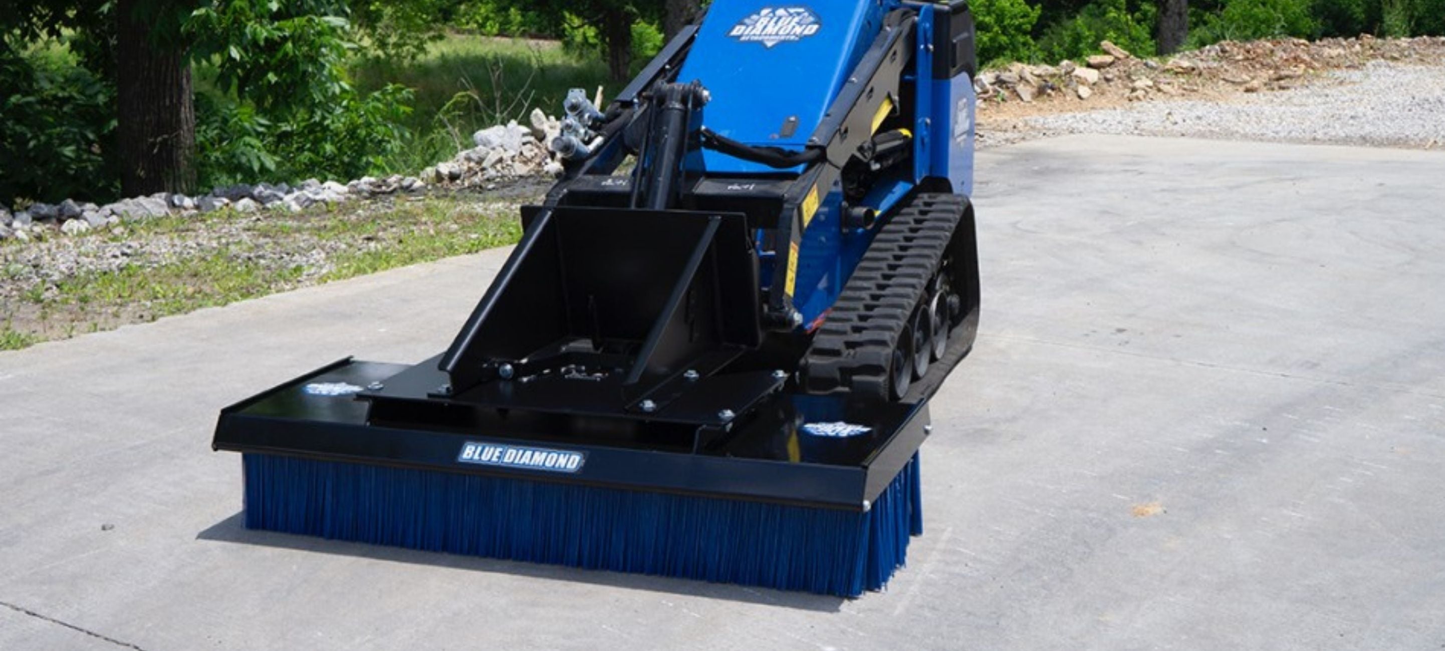 Mini Skid Steer with the push broom attachment by Blue Diamond