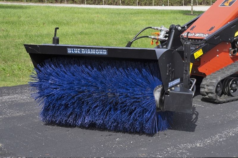 Mini skid steer Ditch Witch using the Blue Diamond angle broom attachment brushing the road 