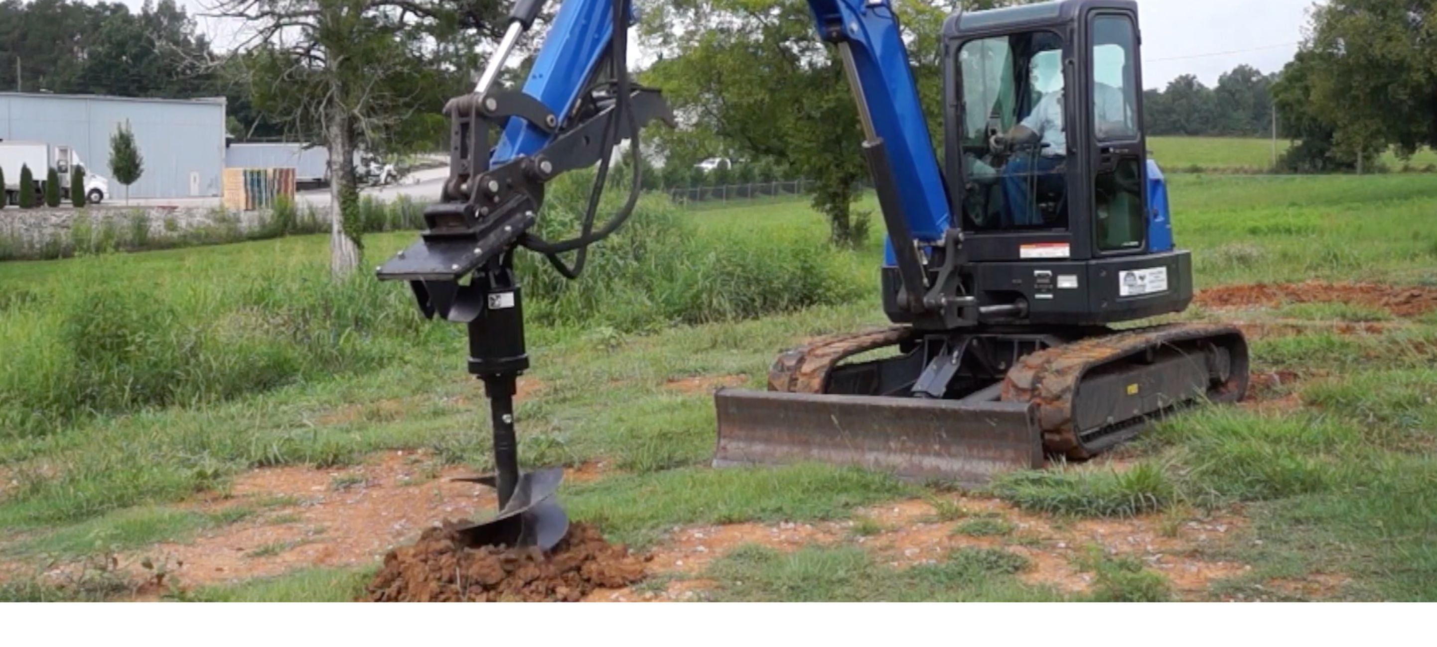 Excavator digging hole with the Blue Diamond auger. 