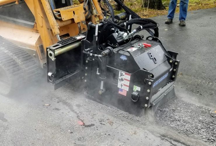 cat-skid-steer-with-the-blue-diamond-cold-planer-attachment-in-action