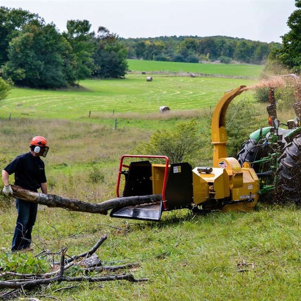 Bx72R-in-the-field-chipping-woods-on-a-john-deer-tractor