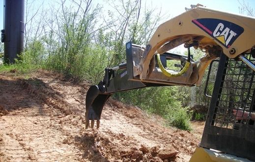 Caterpillar skid steer using the Blue Diamond Backhoe attachment