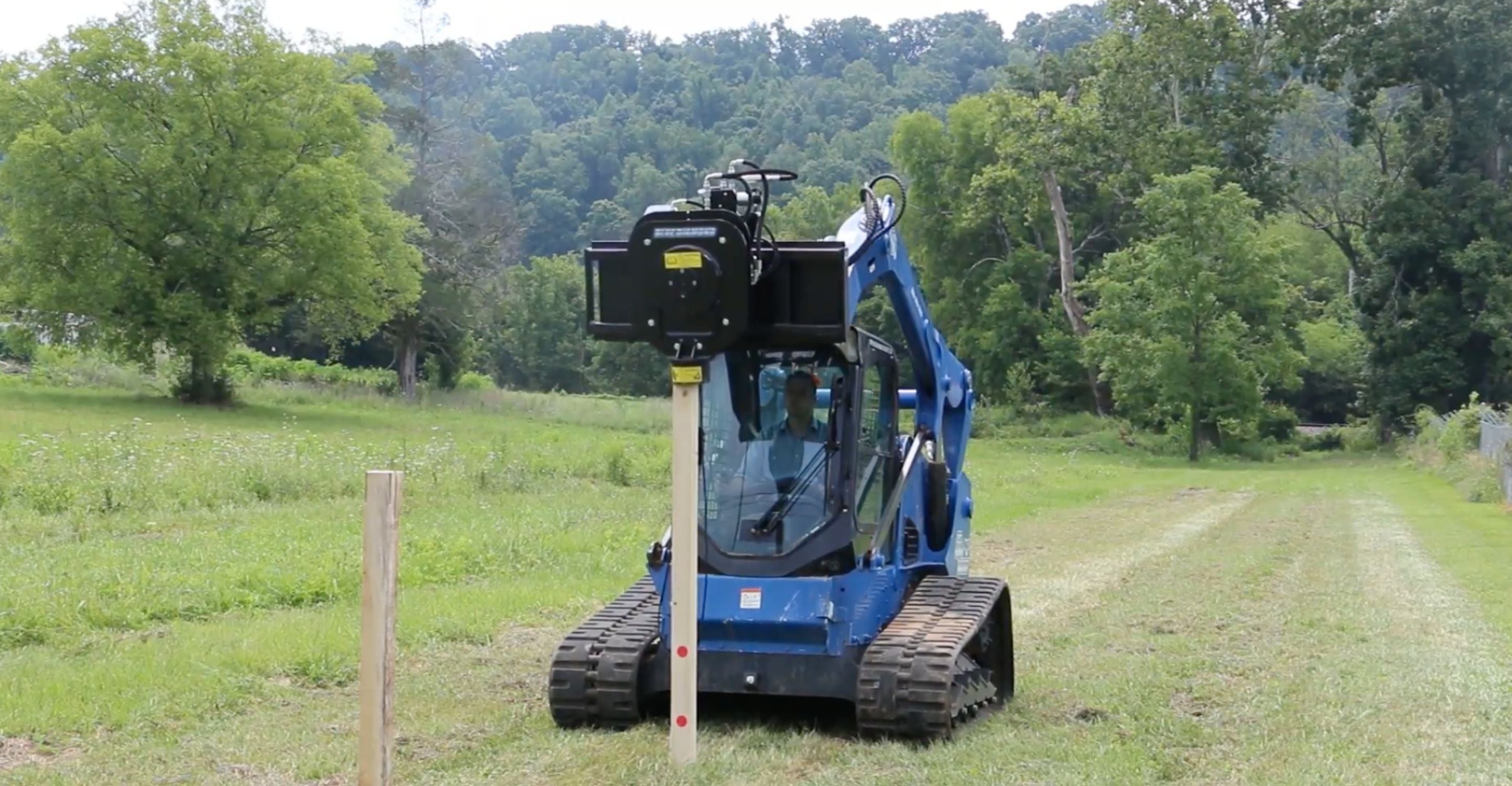 Skid steer with the Blue Diamond fence hog attachment