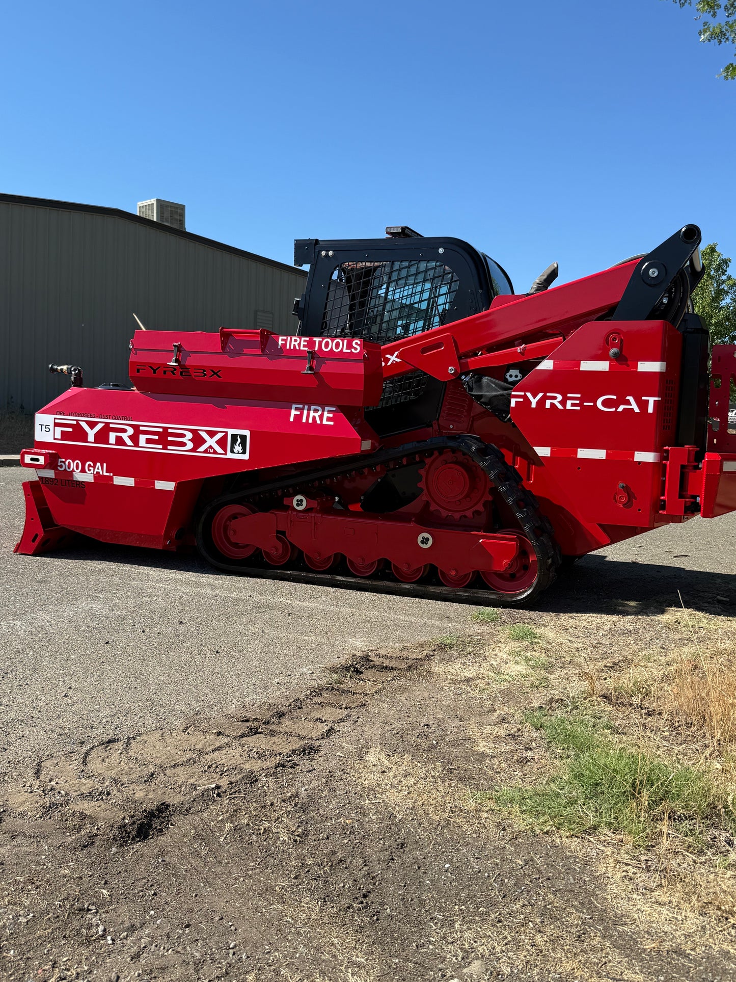 Bright red FYREBX firefighting track loader labeled FYRE-CAT parked outdoors
