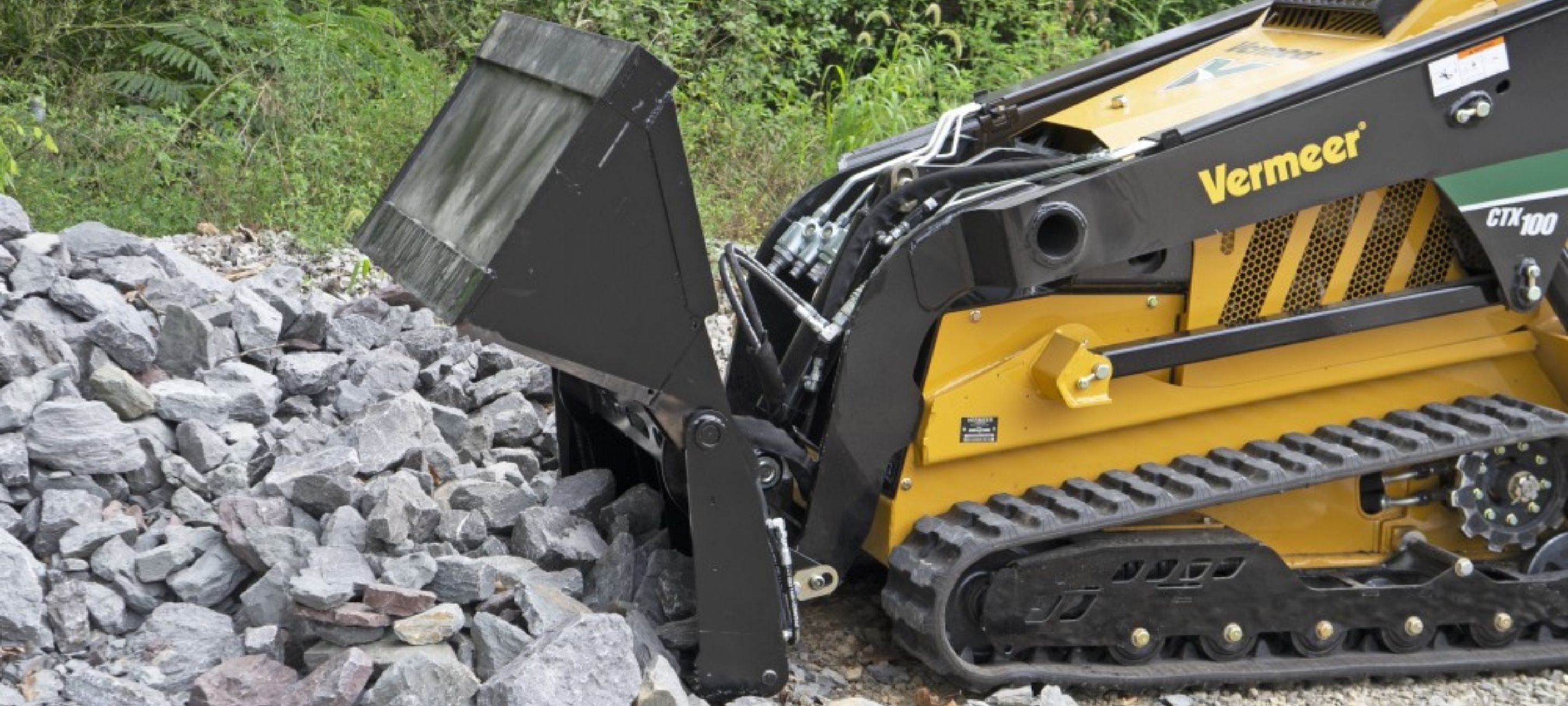 Vermeer mini skid steer picking stones with the 4 in 1 bucket attachment by Blue Diamond