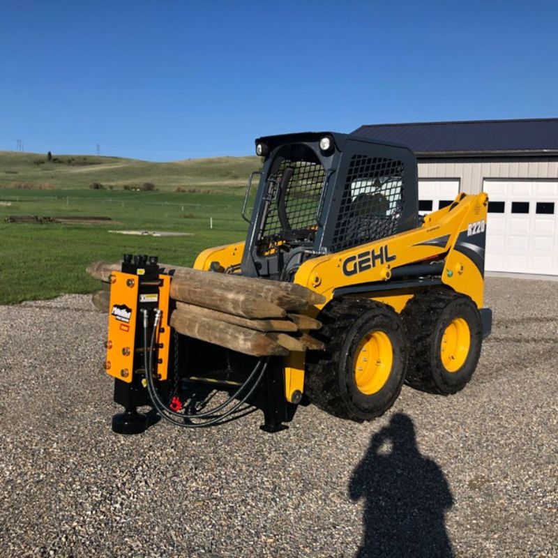 gehl skid steer in gravel parking lot ready to driver posts
