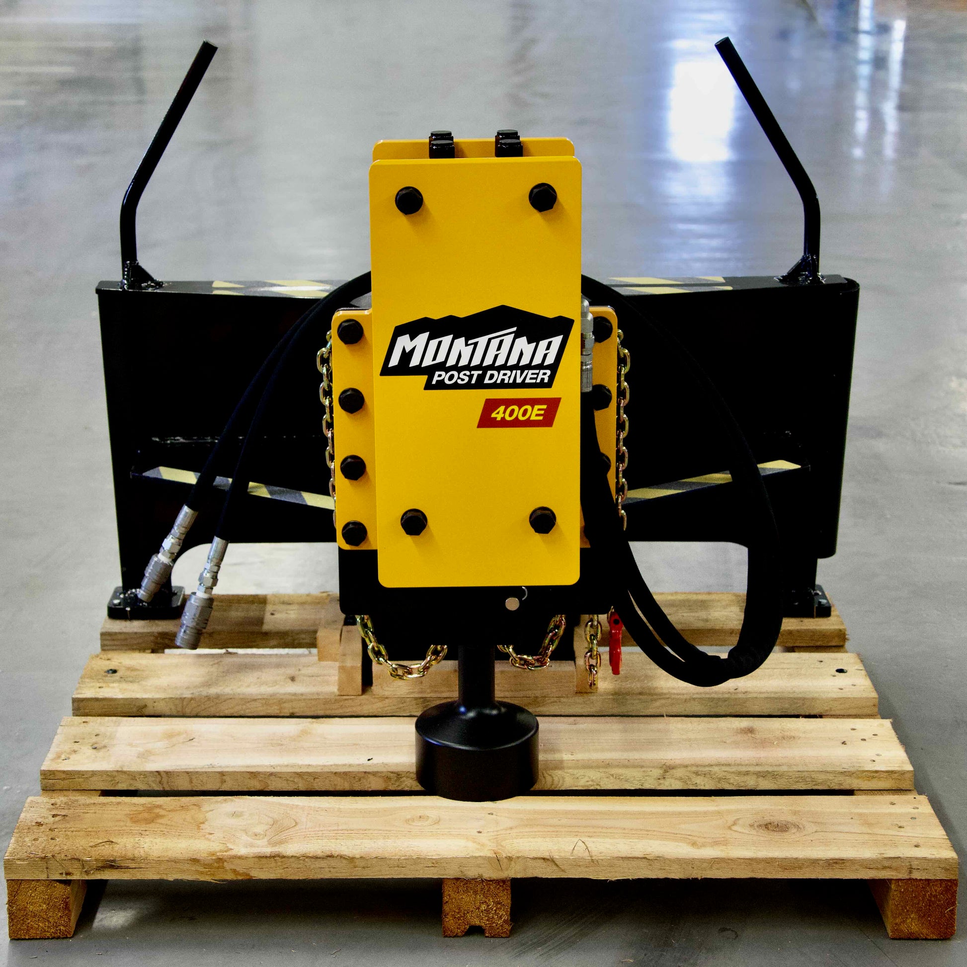 Montana Post Driver 400E secured on a pallet with hydraulic hoses and mounting frame in a warehouse
