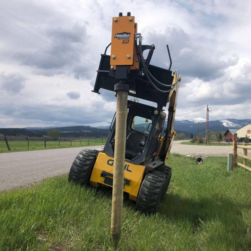 gehl skid steer driving post on the side of the road