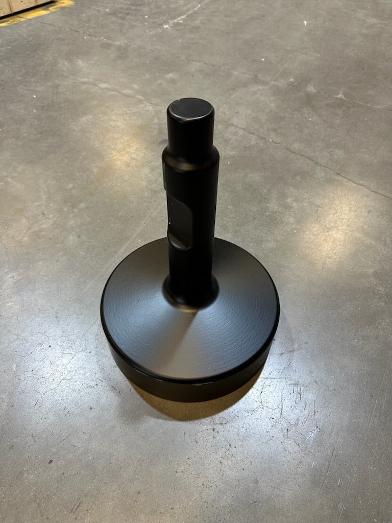 Black cylindrical metal attachment with a solid round base standing upright