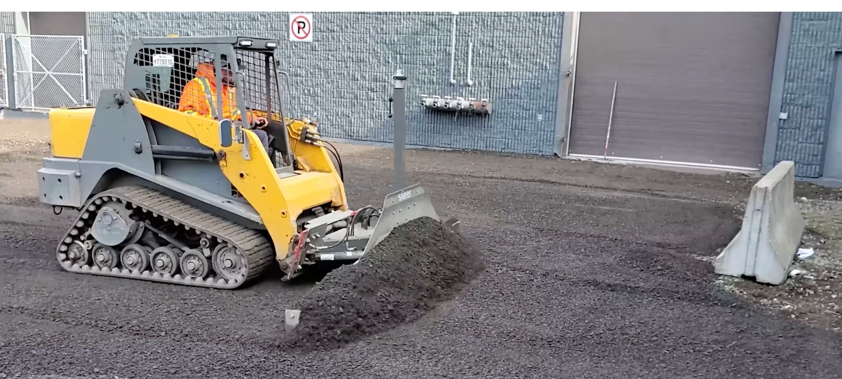 Skid steer grading the ground with the help of grading blade attachment by Skeer System