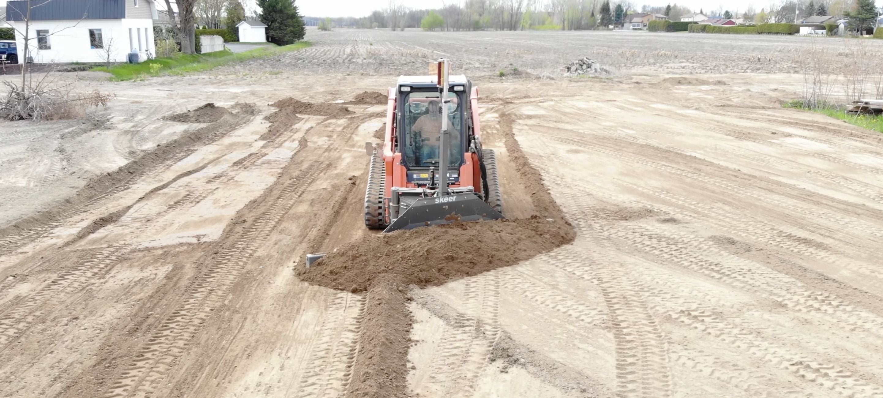 Skid steer in the field with the Skeer System attachments