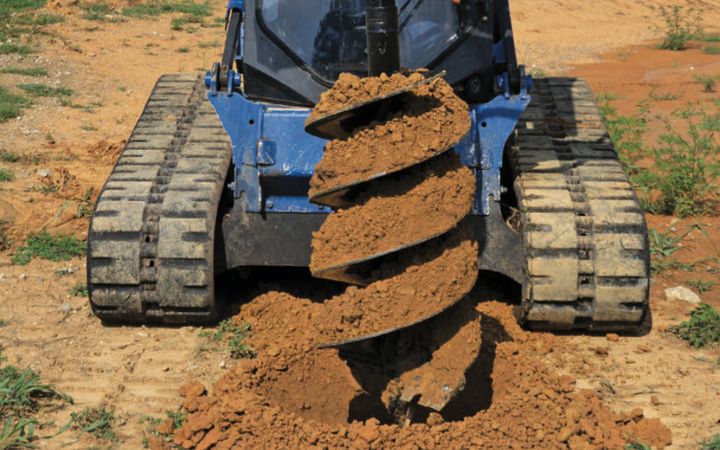 Blue diamond flight auger attachment in action on a skid steer. 