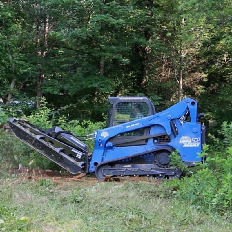 blue diamond extreme duty brush cutter used by skid steer in the forest