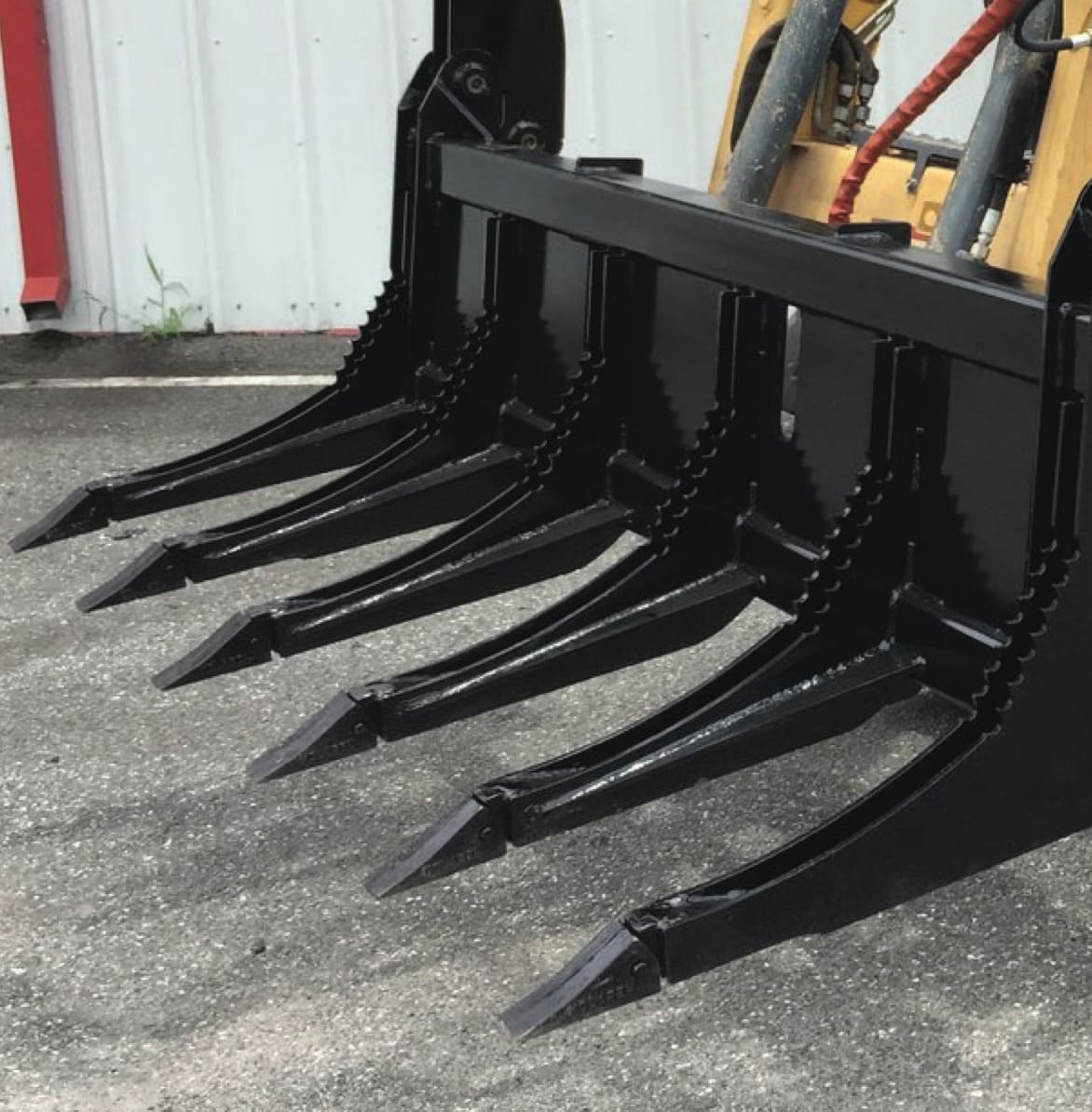 severe duty rake grapple attachment on the ground from mclaren industries