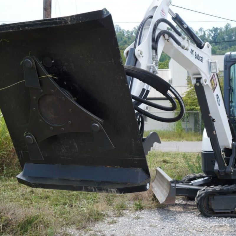 blue diamond brush cutter in action on a mini excavator