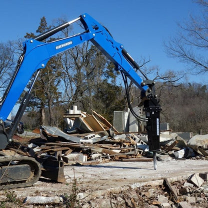 blue diamond excavator hydraulic breaker hammer breaking the ground.