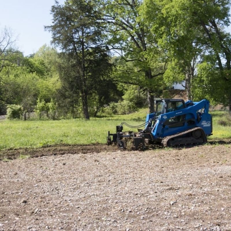 skid steer in the field with the blue diamond power rake  Edit alt text