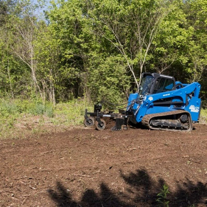 skid steer in action with the blue diamond power rake