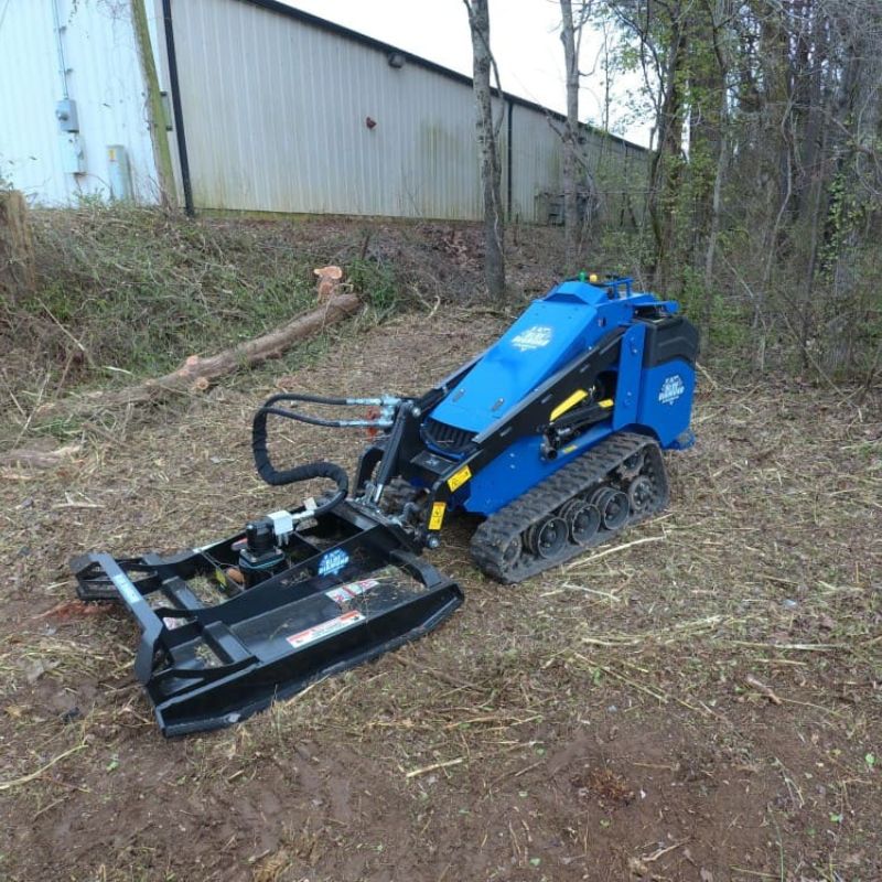 in the field mini skid steer with the blue diamond brush cutter