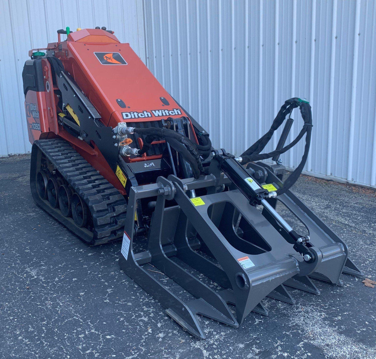 ditch witch mini skid steer with the mini root grapple attachment from berlon