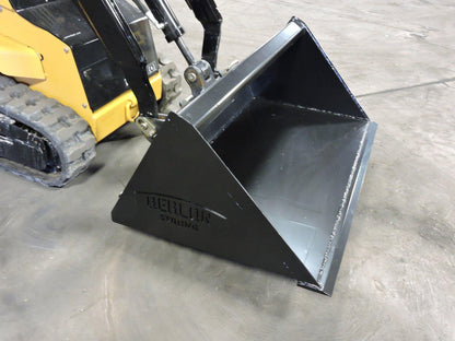 mini skid steer with the Mini Low Pro Bucket attachment on the ground from berlon