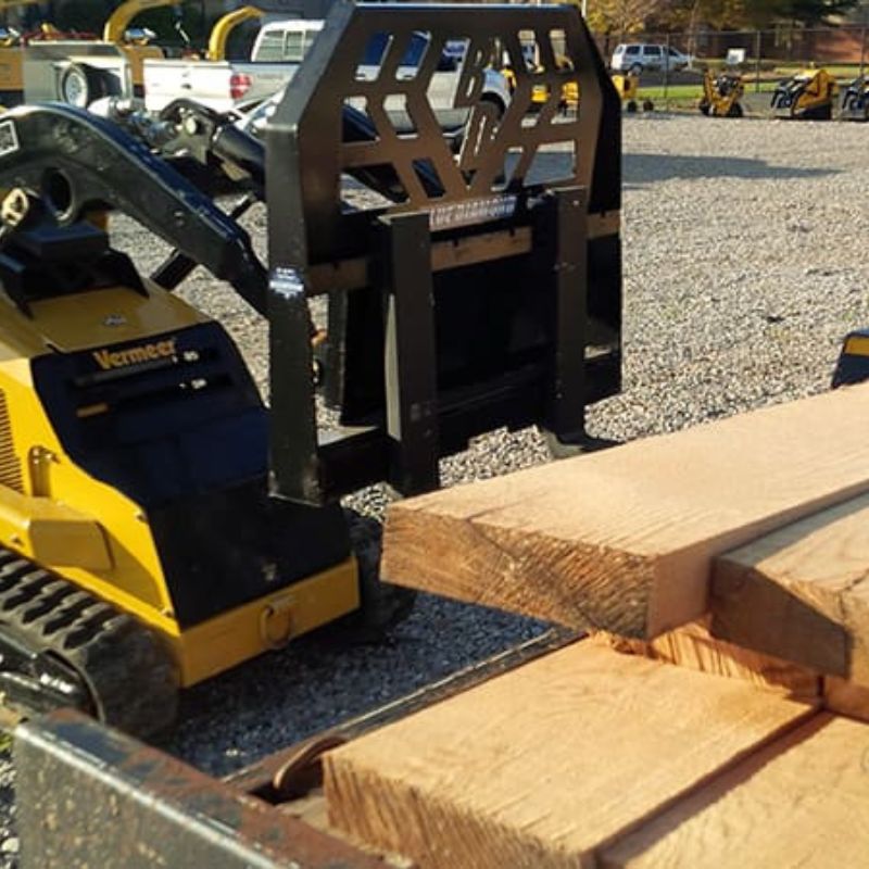 mini skid steer with blue diamond mini pallet fork lifting lumber