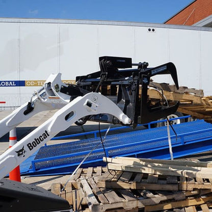 bobcat mini skid steer grappling a pallet using the blue diamond mini root grapple