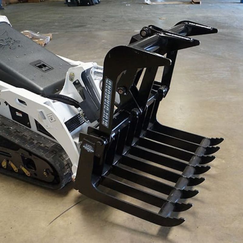 mini skid steer root grapple on the ground from blue diamond