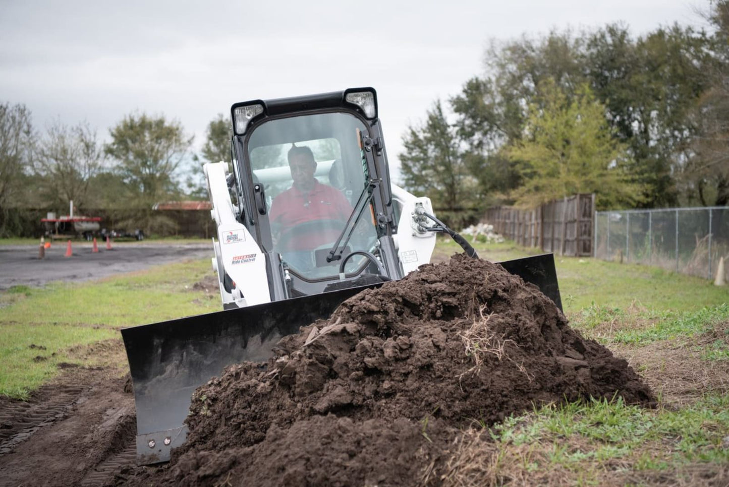 bobcat skid steer in action with the dozer blade from mclaren industries