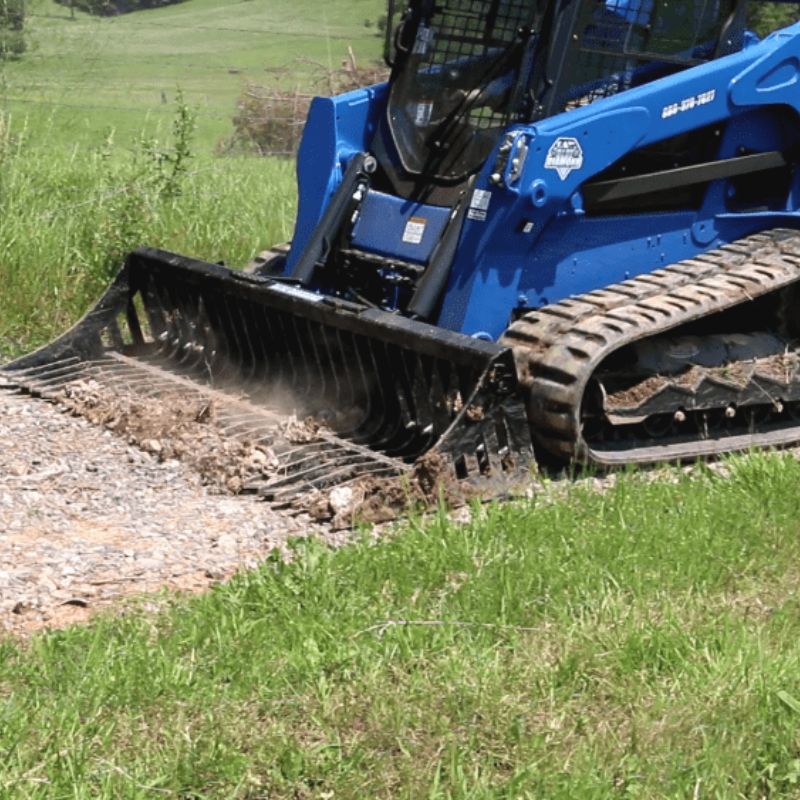 skid steer with blue diamond rock bucket attachment. in action