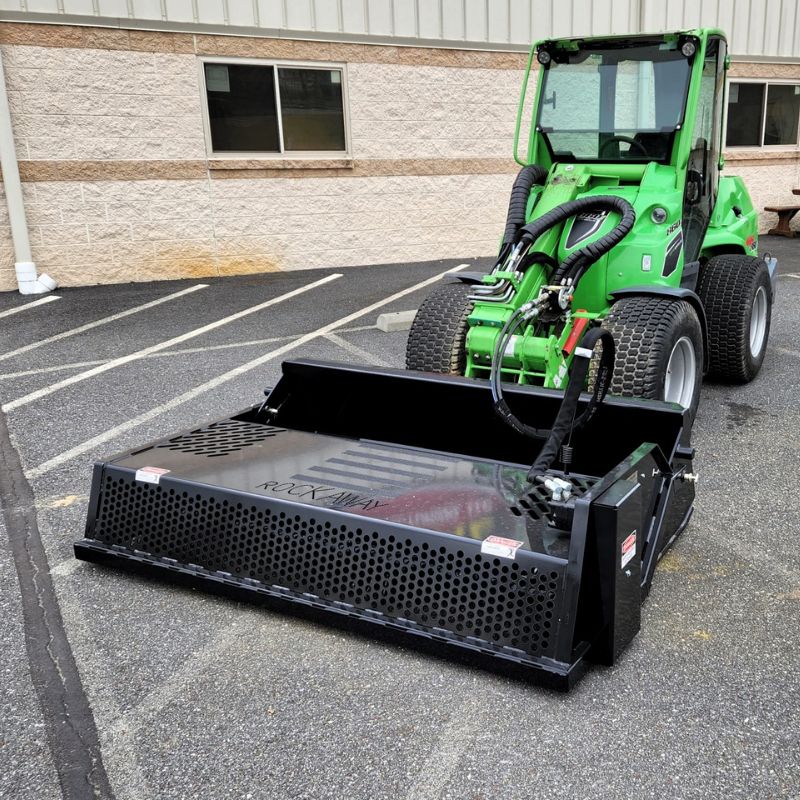 mini-skid-steer-using-the-landscape-rake-attachment-from-rockaway