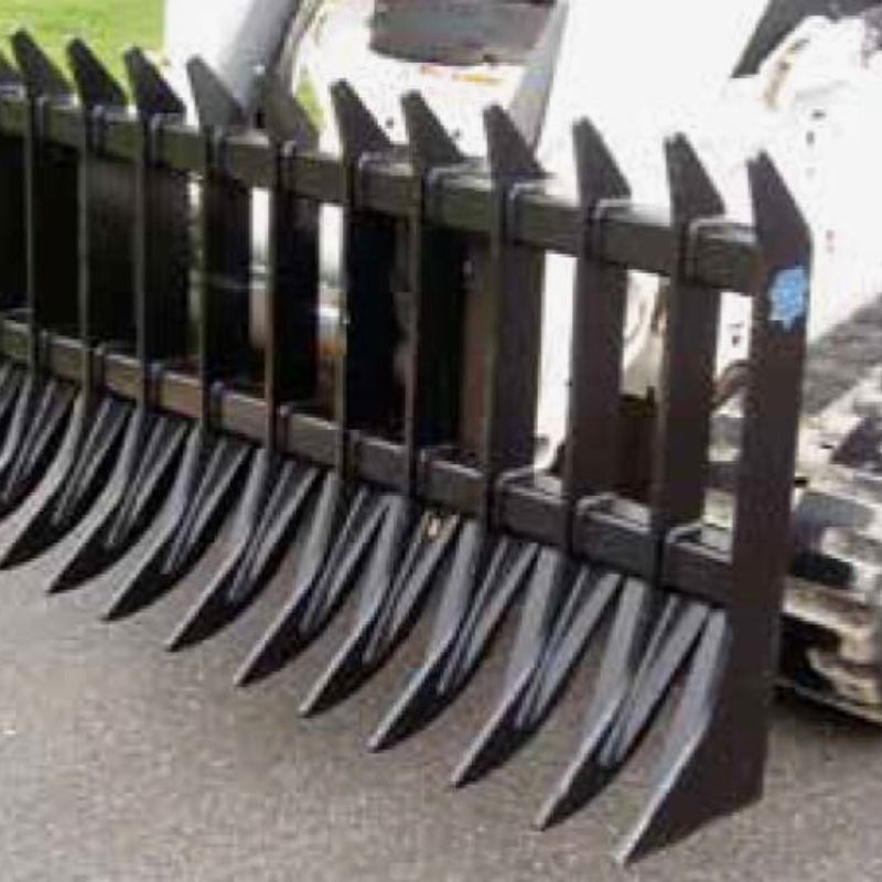 skid steer with the blue diamond severe duty root rake in use