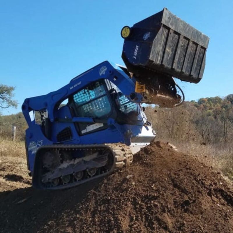 skid steer with blue diamond screening bucket attachment in action.
