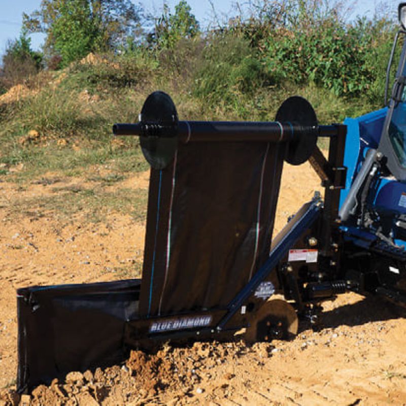 blue diamond silt fence installer attachment being used on a skid steer