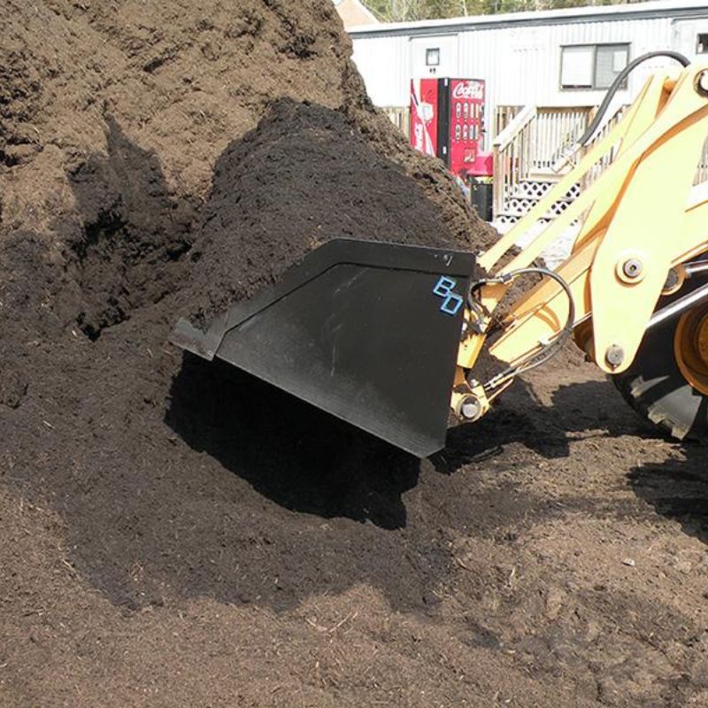 snow and mulch bucket attachment in use on a skid steer