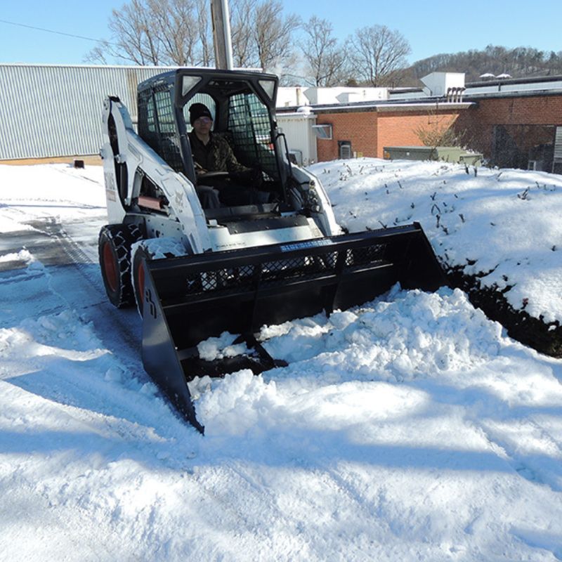 clearing the snow with a skid steer using the blue diamond snow and mulch bucket attachment